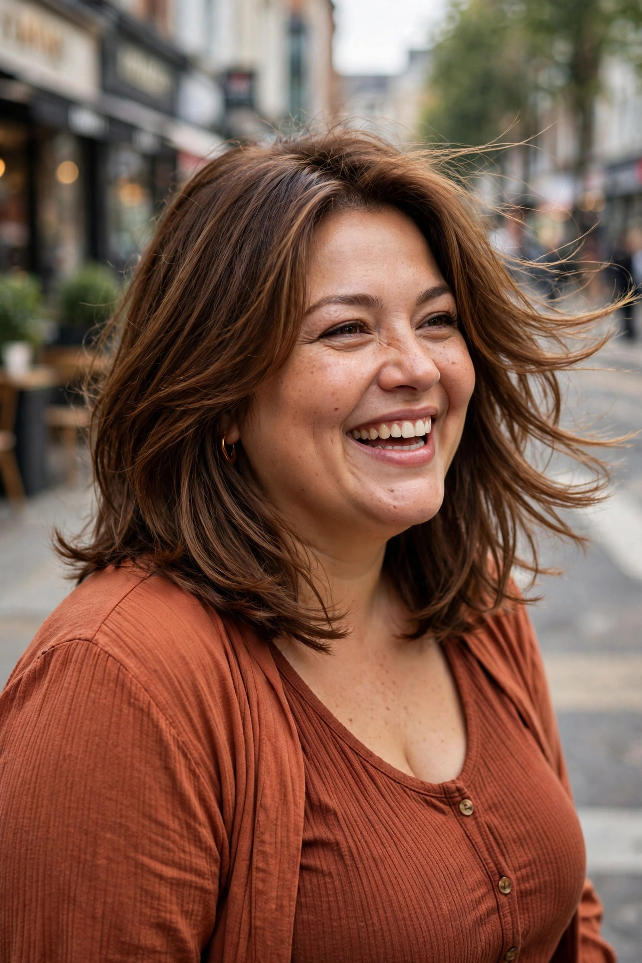 Soft layered lob with long blended layers in warm chestnut brown hair, styled with gentle movement