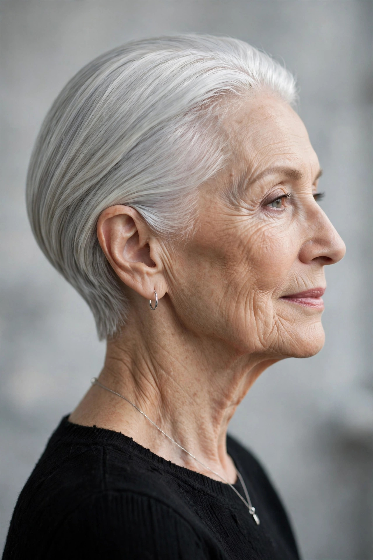 Sleek silver long pixie with ear-length sides for a mature woman